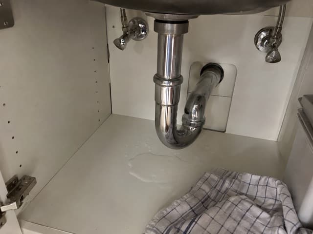 Foto der Mieterin: Wasser auf dem Boden des Spülenschranks unter dem Siphon.